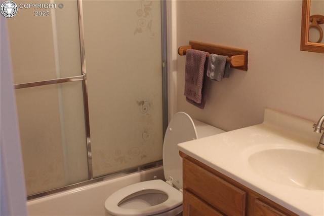 full bathroom with vanity, shower / bath combination with glass door, and toilet