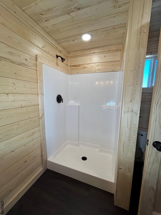 bathroom featuring walk in shower, wooden ceiling, and wood walls