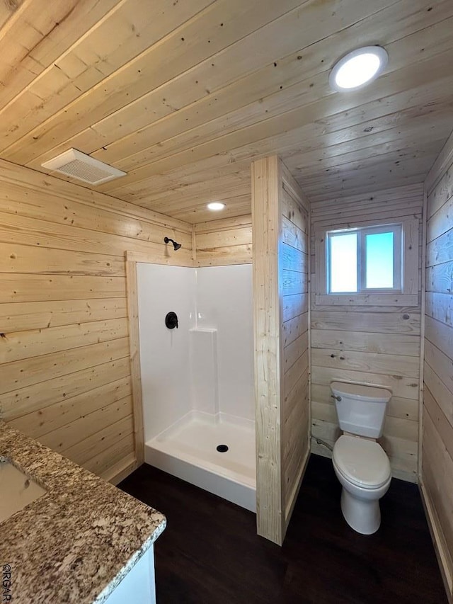 bathroom with wood walls, vanity, wood ceiling, walk in shower, and toilet