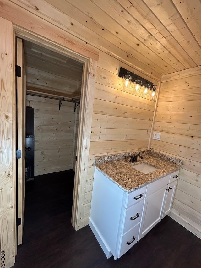 bathroom featuring sink, wooden walls, and wooden ceiling