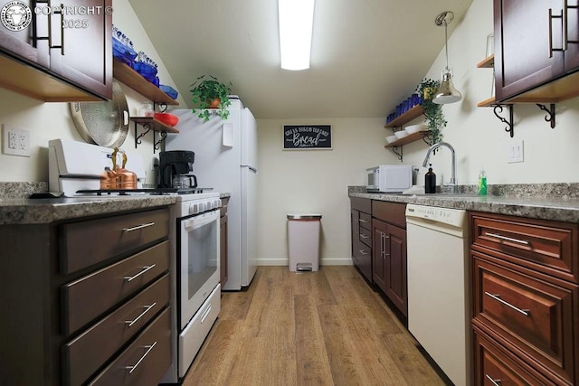 kitchen with open shelves, dark countertops, light wood-style floors, a sink, and white appliances