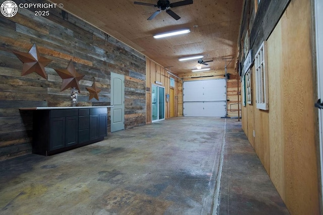 garage featuring wood walls and a ceiling fan