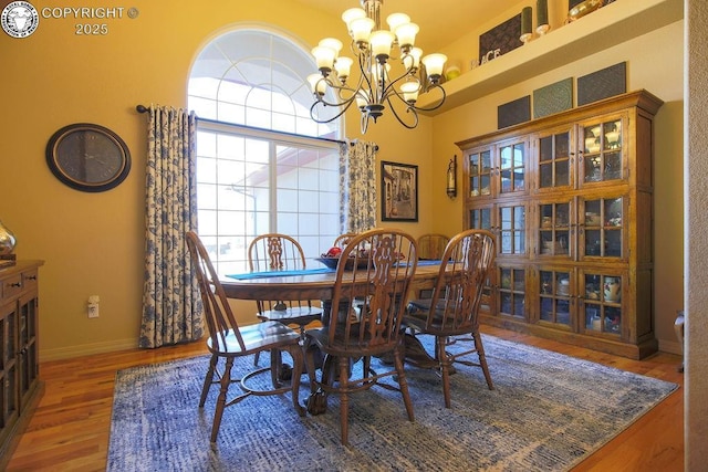 dining area with an inviting chandelier, baseboards, and wood finished floors