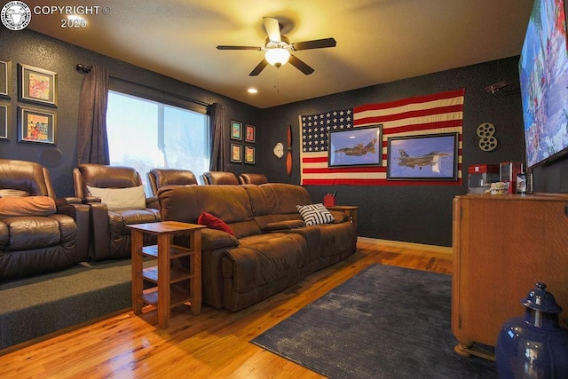 cinema with baseboards, a ceiling fan, and wood finished floors