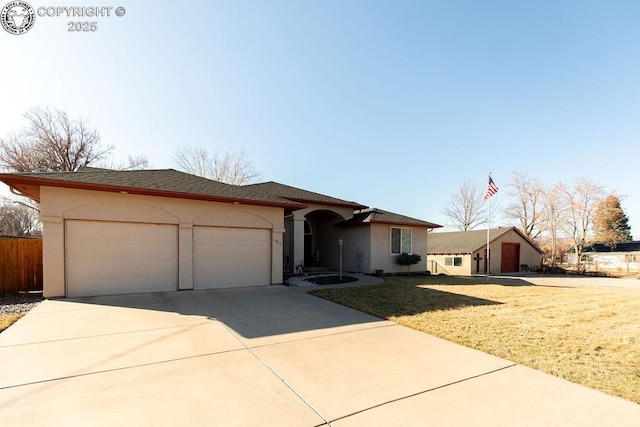 single story home featuring a garage, driveway, a front lawn, and stucco siding