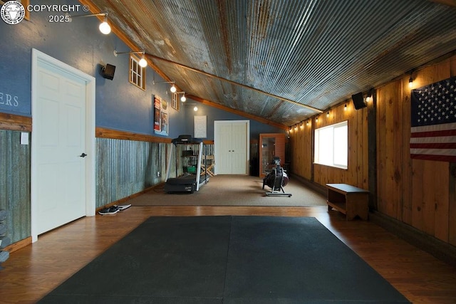 workout room featuring lofted ceiling, wood walls, wood ceiling, and wood finished floors