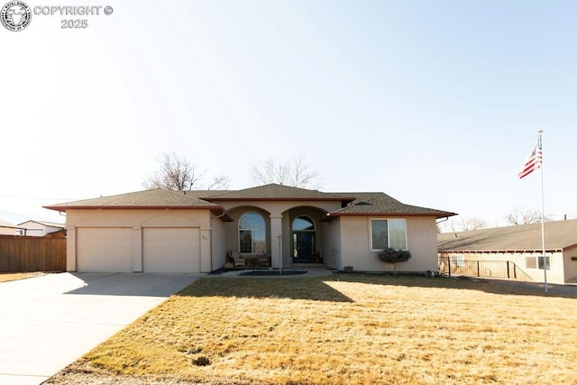 view of front of property featuring driveway, a garage, fence, and stucco siding