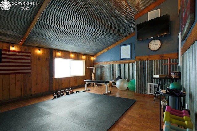 workout room with lofted ceiling and wood finished floors