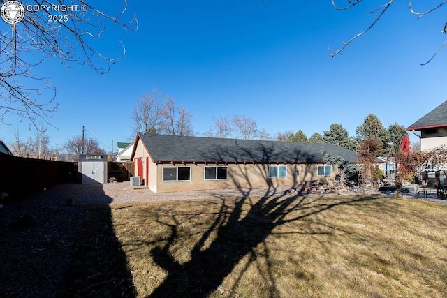 back of house with a yard, fence, a gate, and stucco siding