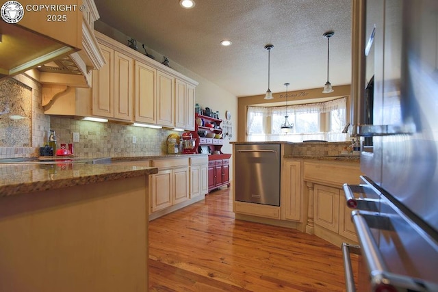 kitchen with light stone countertops, stainless steel appliances, premium range hood, hanging light fixtures, and decorative backsplash