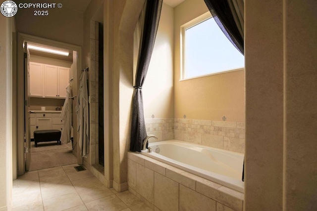 full bath featuring a garden tub, a stall shower, and tile patterned flooring