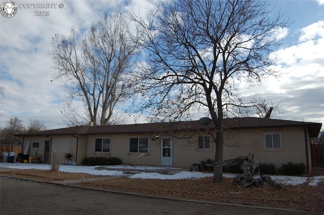 single story home featuring an attached garage and stucco siding