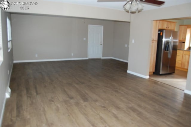 unfurnished living room with dark wood-style floors, baseboards, and a ceiling fan