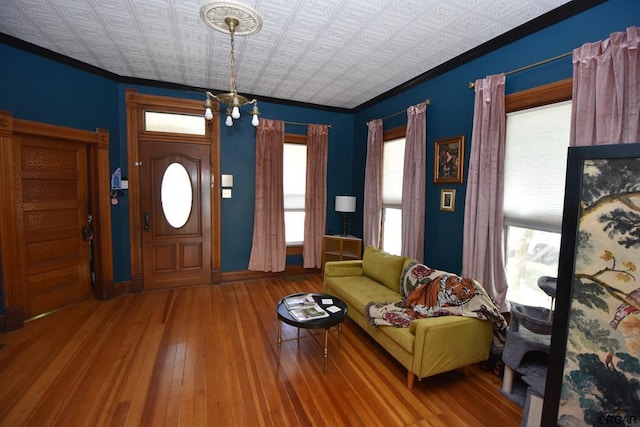 entrance foyer with crown molding and hardwood / wood-style floors