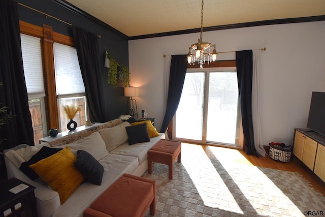 living room featuring crown molding, a notable chandelier, and light hardwood / wood-style flooring