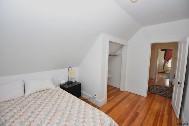 bedroom featuring vaulted ceiling, hardwood / wood-style floors, and a closet