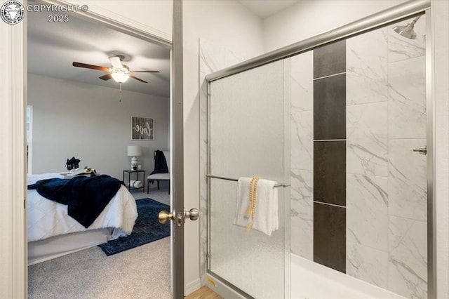 bathroom featuring ceiling fan and a shower with shower door