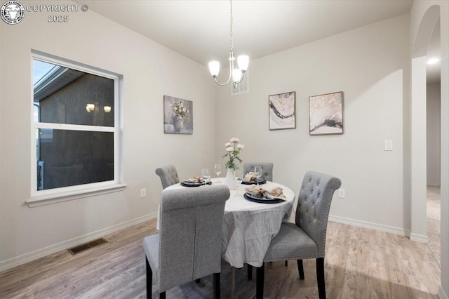 dining area featuring an inviting chandelier and light wood-type flooring