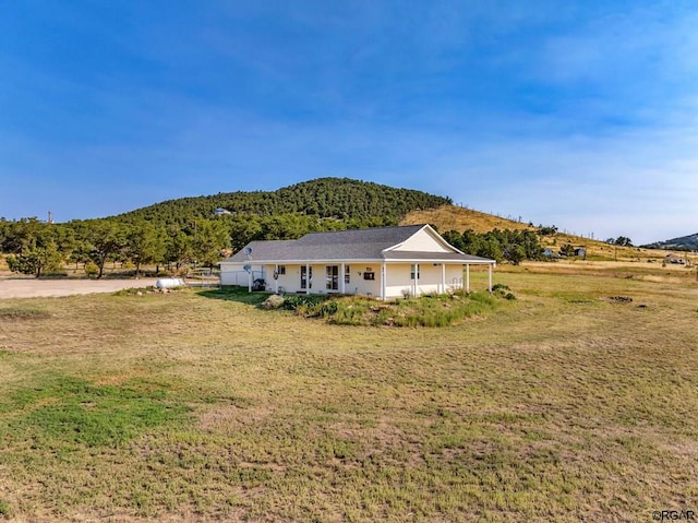 exterior space with a mountain view and a front lawn