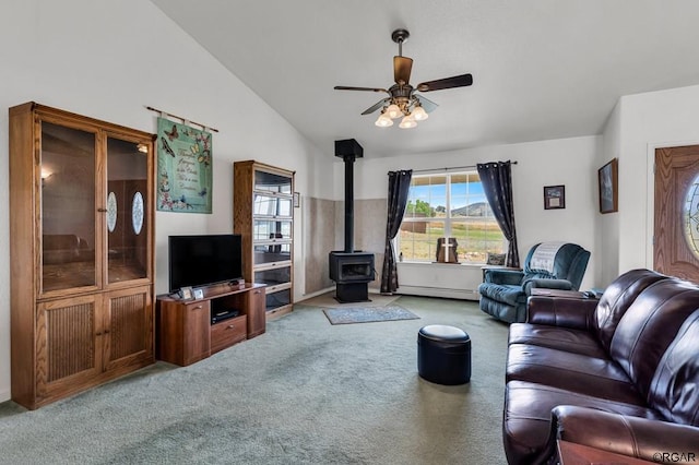 living room featuring a baseboard radiator, vaulted ceiling, light carpet, and a wood stove