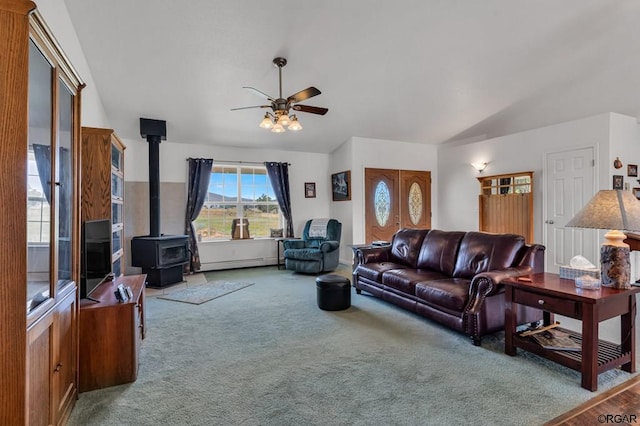 living room featuring a baseboard radiator, carpet, a wood stove, and ceiling fan