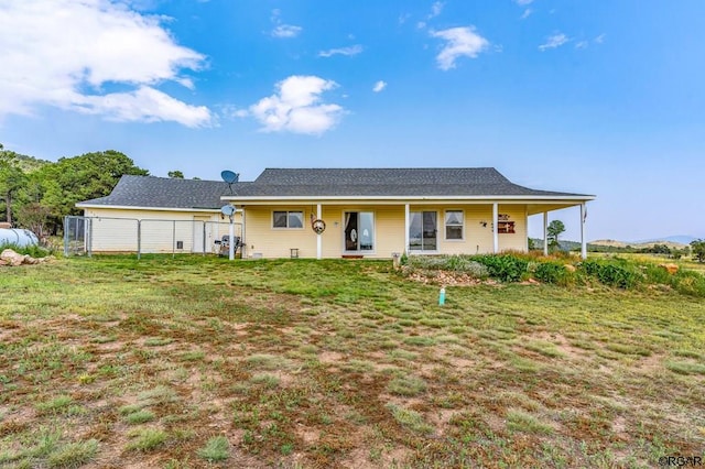 back of property featuring a yard and covered porch