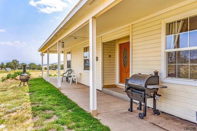 view of patio / terrace with a fire pit, grilling area, and a porch