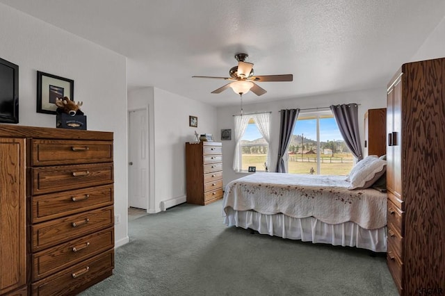 bedroom with a baseboard heating unit, a textured ceiling, carpet floors, and ceiling fan