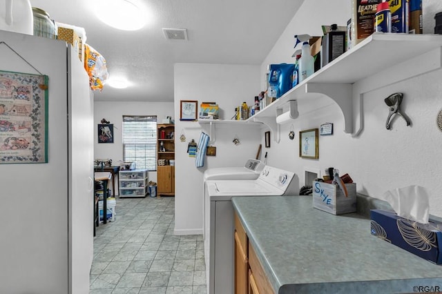 washroom with washer and clothes dryer and a textured ceiling