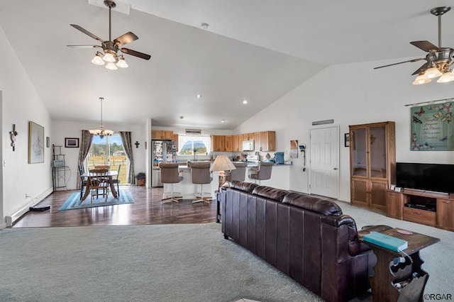 living room featuring lofted ceiling, ceiling fan with notable chandelier, and carpet