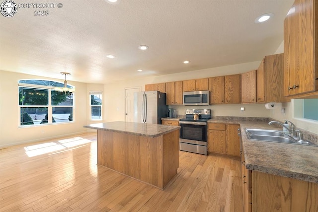 355 Antero Dr, Canon City, CO 81212 - kitchen with appliances with stainless steel finishes, brown cabinets, dark countertops, a center island, and recessed lighting