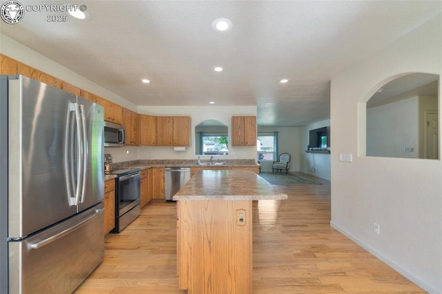 355 Antero Dr, Canon City, CO 81212 - kitchen with appliances with stainless steel finishes, a kitchen island, light wood-style floors, recessed lighting, and brown cabinets