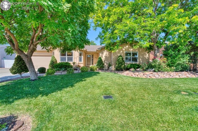 355 Antero Dr, Canon City, CO 81212 - obstructed view of property with stucco siding, a garage, and a front lawn