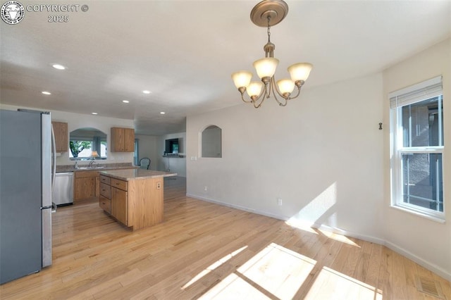 355 Antero Dr, Canon City, CO 81212 - kitchen featuring appliances with stainless steel finishes, arched walkways, light wood-style flooring, brown cabinets, and light countertops