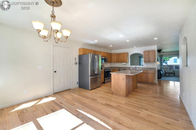 355 Antero Dr, Canon City, CO 81212 - kitchen featuring stainless steel appliances, arched walkways, brown cabinetry, a chandelier, and recessed lighting