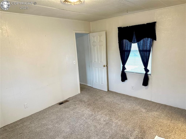 carpeted empty room featuring visible vents