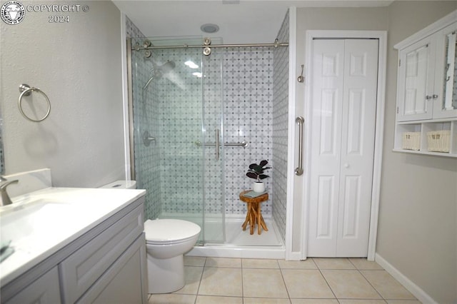 bathroom featuring vanity, tile patterned flooring, a shower with shower door, and toilet