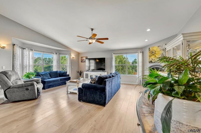 living room featuring lofted ceiling, light hardwood / wood-style flooring, and a wealth of natural light