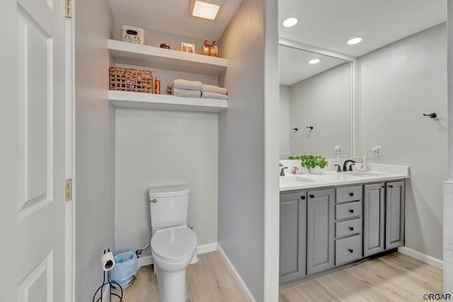 bathroom featuring vanity, wood-type flooring, and toilet