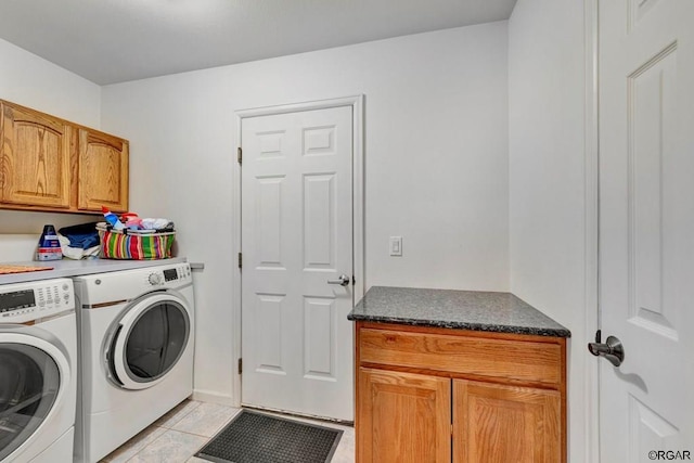 washroom with cabinets, separate washer and dryer, and light tile patterned floors