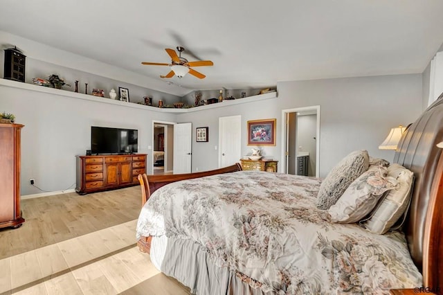 bedroom with lofted ceiling, ensuite bath, ceiling fan, and light wood-type flooring