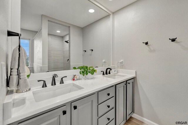 bathroom featuring a shower, hardwood / wood-style floors, and vanity