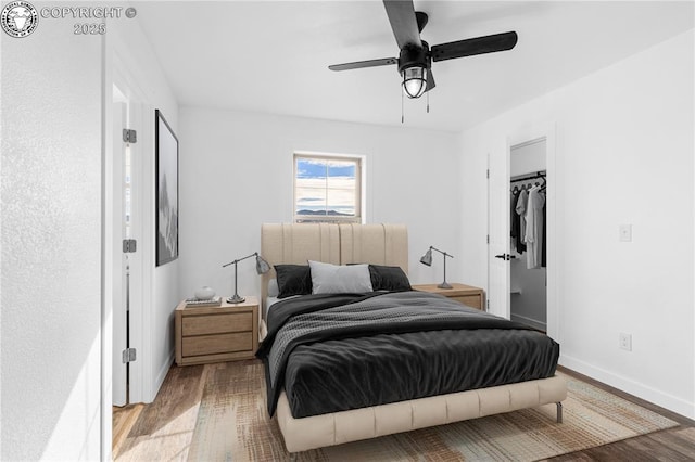 bedroom featuring light wood-type flooring, ceiling fan, and a closet