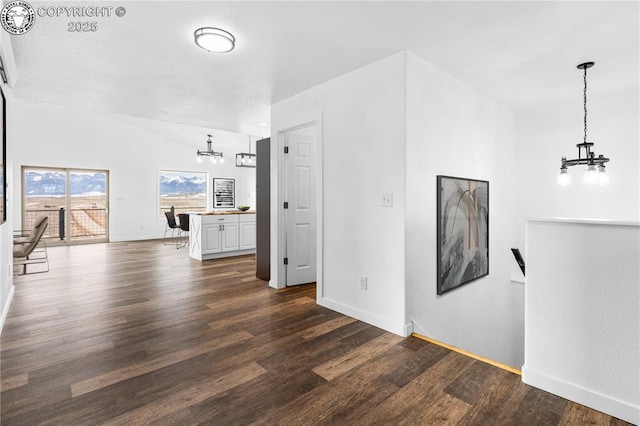 unfurnished living room with dark hardwood / wood-style floors and a notable chandelier