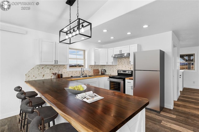 kitchen with sink, appliances with stainless steel finishes, hanging light fixtures, white cabinets, and kitchen peninsula