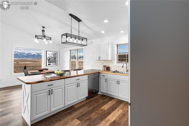 kitchen with kitchen peninsula, dishwasher, and white cabinets