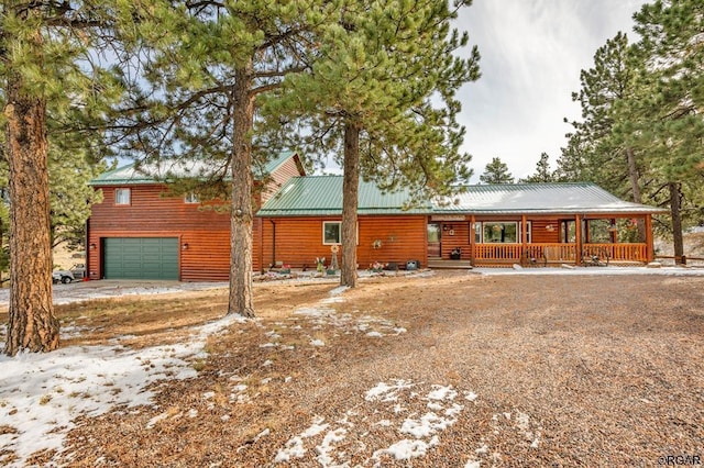 log cabin with a garage and covered porch