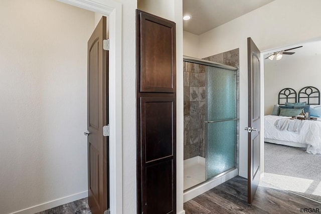 bathroom featuring hardwood / wood-style flooring, ceiling fan, and walk in shower