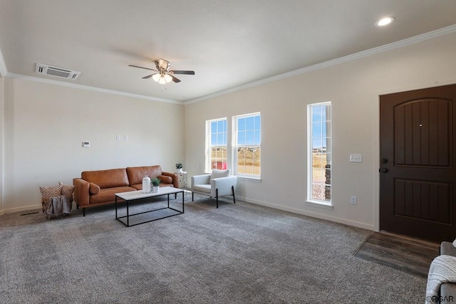 living room with dark carpet, ornamental molding, and ceiling fan