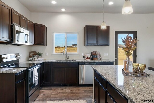 kitchen featuring pendant lighting, dark brown cabinetry, appliances with stainless steel finishes, and sink